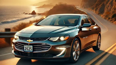 2025 Chevrolet Malibu driving on a coastal highway at sunset.