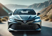 2025 Toyota Camry Hybrid with sleek design, LED headlights, and aerodynamic lines on a scenic road.